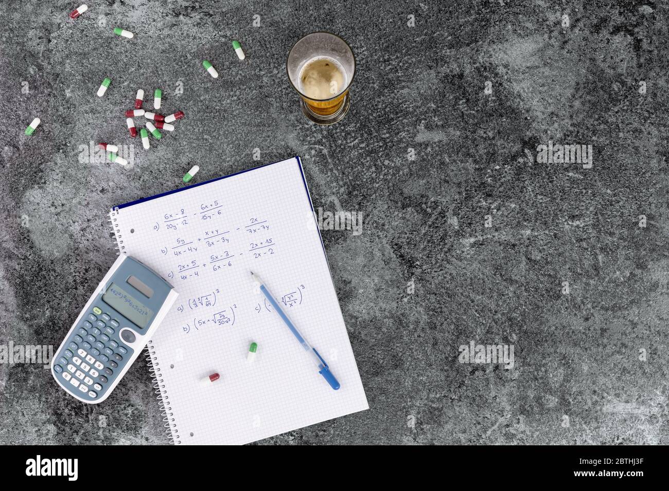 the excessive consumption of alcohol, drugs and medicines damages health and hinders learning, hand-written notes. calculator beer glass and pills on Stock Photo
