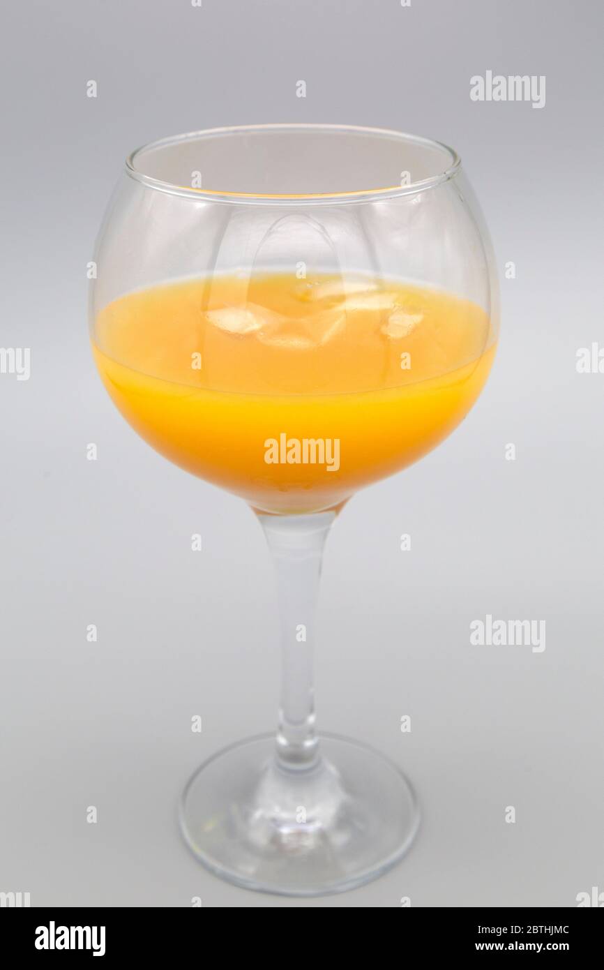 An Alabama Slammer served in a balloon glass. The cocktail features