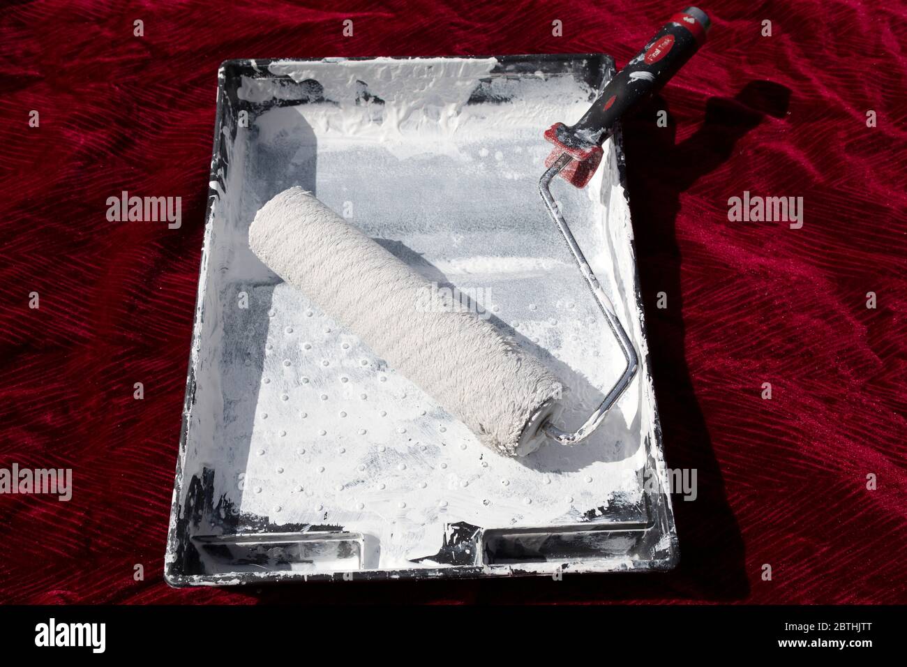 A roller and paint brushes in a paint tray. The are used to apply paint