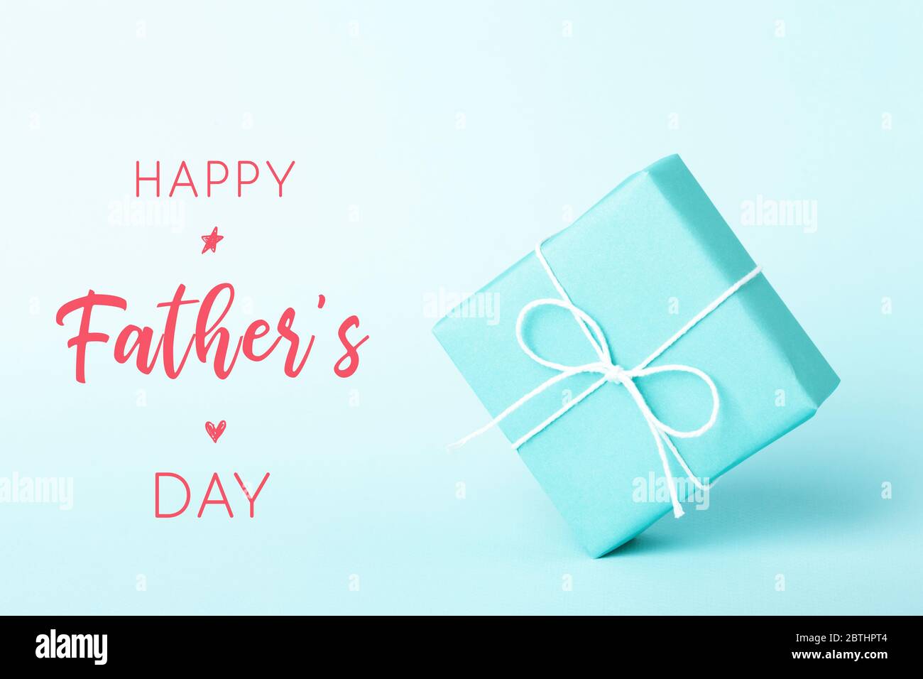 Turquoise gift box in weightlessness on turquoise background. Happy Father's Day card. Stock Photo