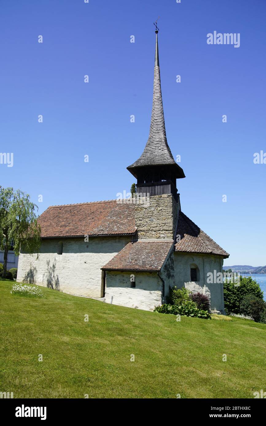 Church in village Einingen is idyllically situated on the banks of Lake Thun (Thunersee). Bernese Oberland, Bern, Switzerland. Stock Photo