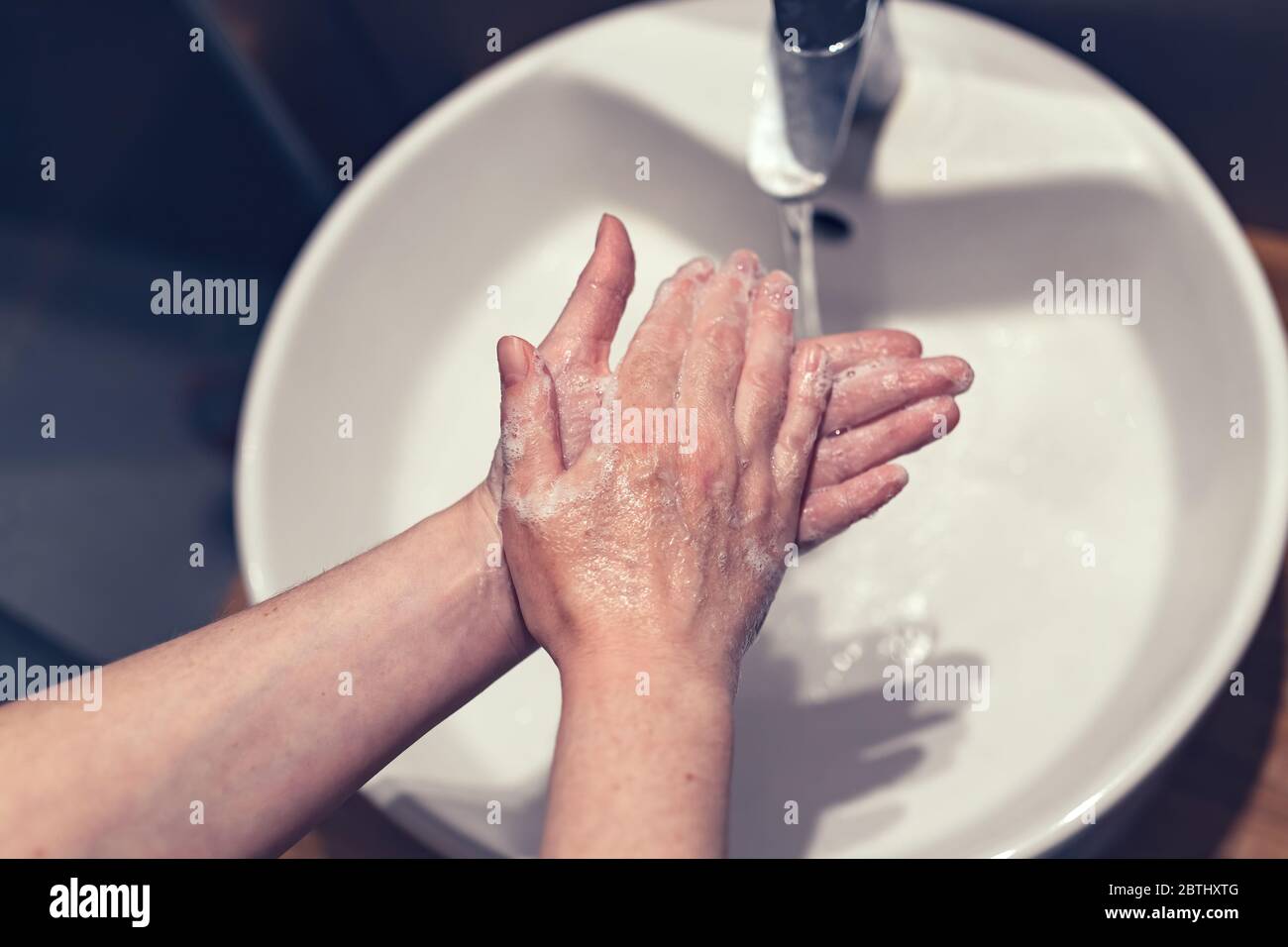 Woman washing hands in bathroom, health care and hygiene, selective focus Stock Photo