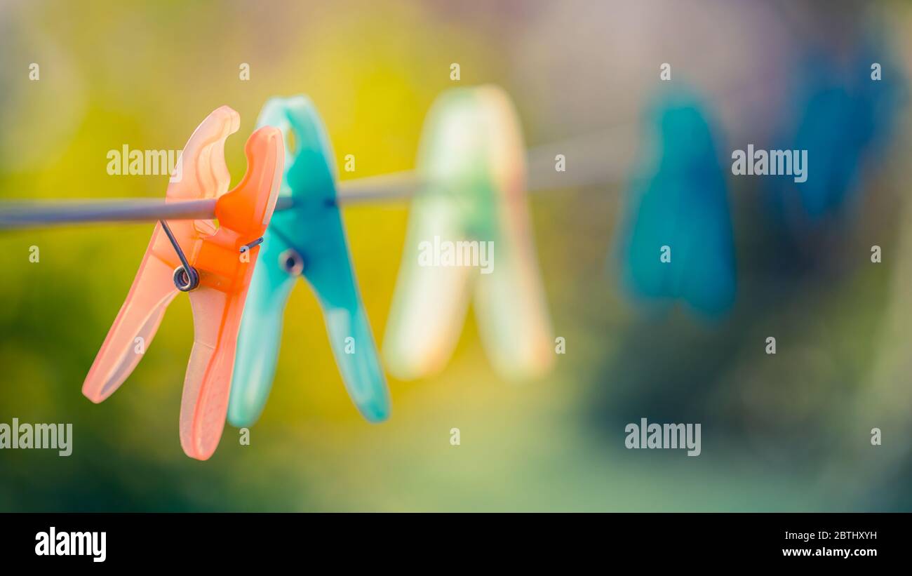 Plastic clothespin hanging on rope with burred outdoor scene Stock Photo