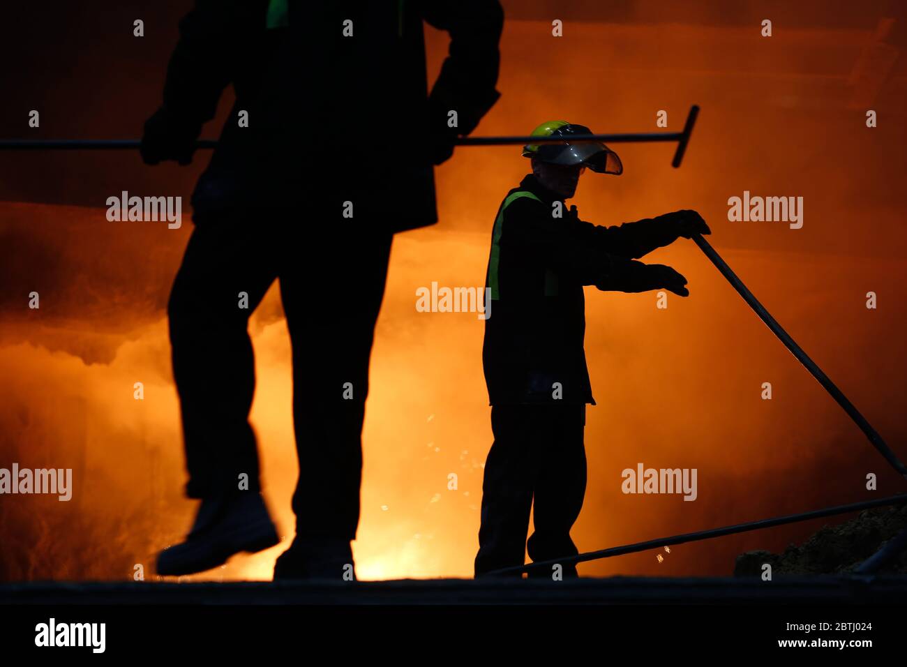 Blast furnace workers duing iron production Stock Photo