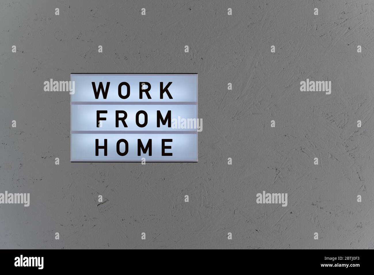 Lightbox with word work from home on wood background Stock Photo