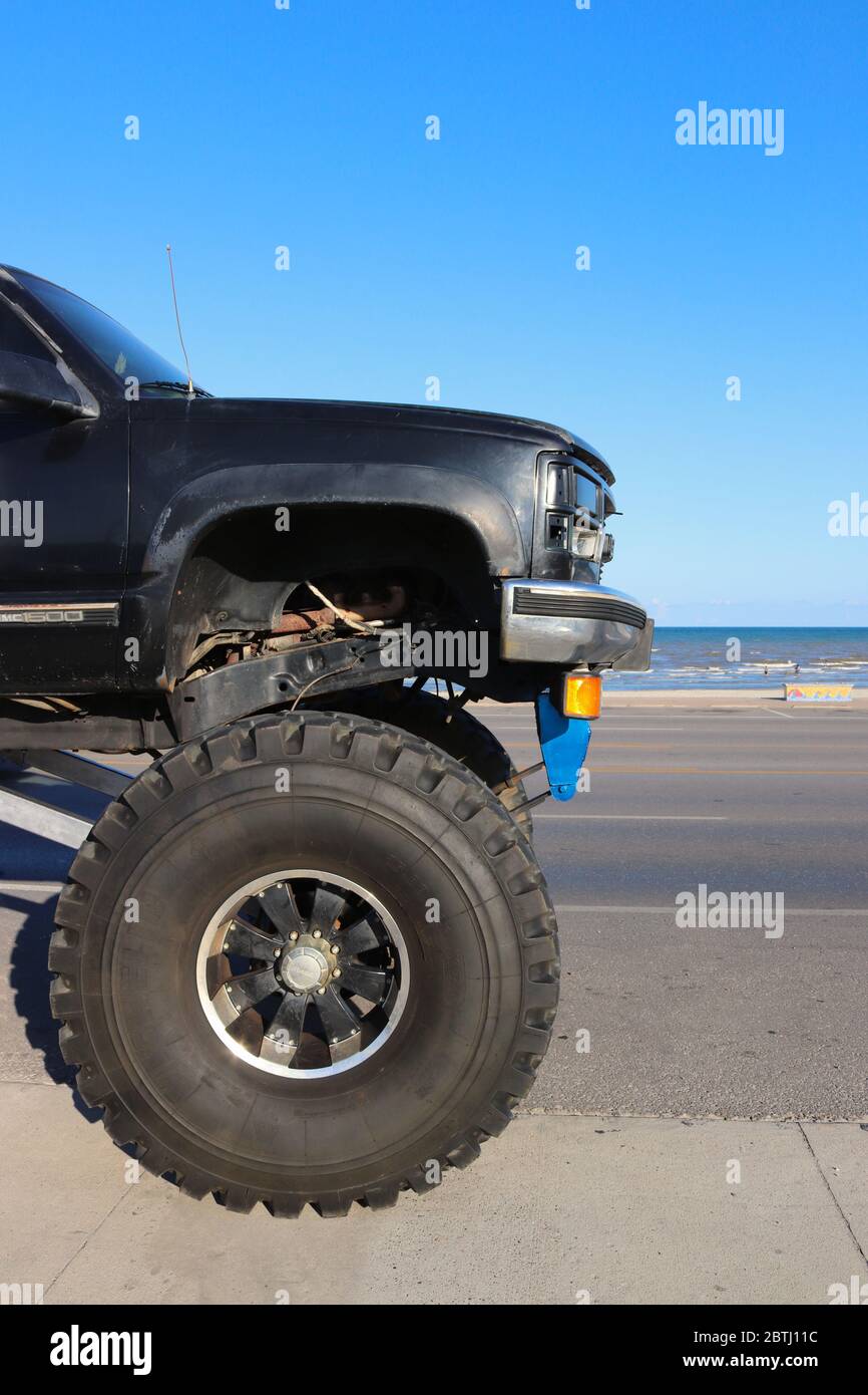 GALVESTON, TEXAS, USA - JUNE 9, 2018: A giant monster truck is parked on the street next to the ocean. Stock Photo