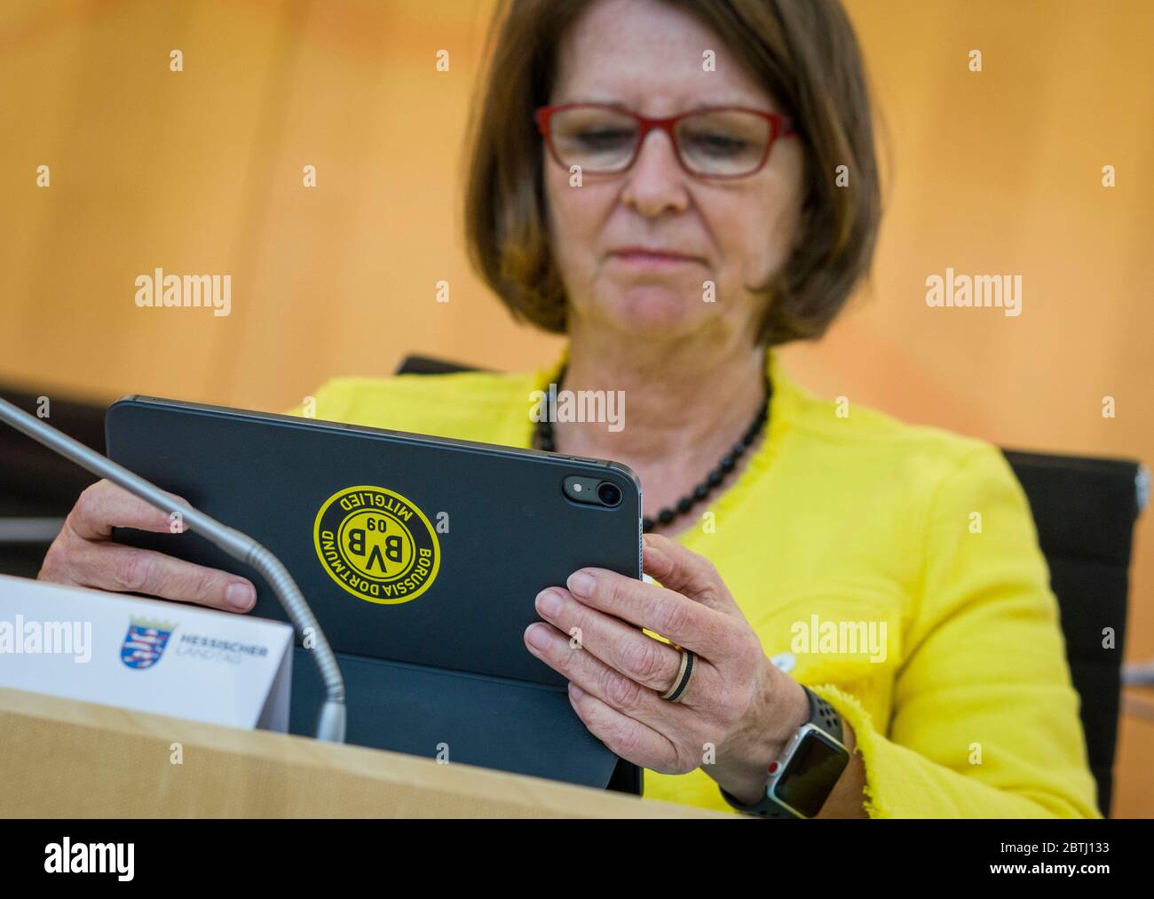 Wiesbaden, Germany. 26th May, 2020. Priska Hinz, the Hessian Minister for Environmental Protection, Agriculture and Consumer Protection (Greens), sits with her laptop on the government bench during the plenary debate in the Hessian state parliament. It bears a sticker with the logo of Borussia Dortmund, the Bundesliga football club. The minister is a member of the club. Credit: Frank Rumpenhorst/dpa/Alamy Live News Stock Photo