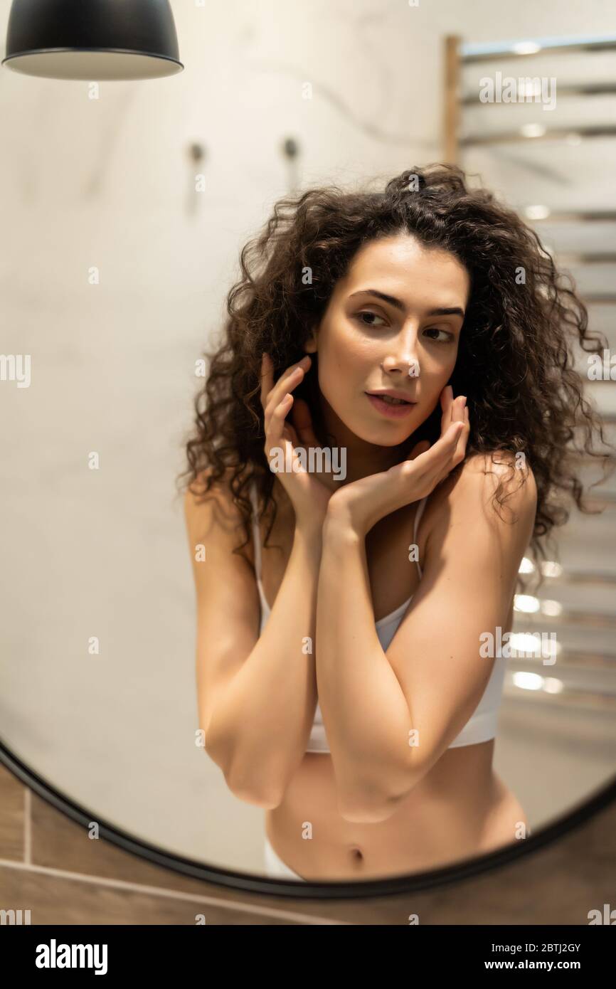 Woman looking on reflection in the mirror after shower Stock Photo Alamy