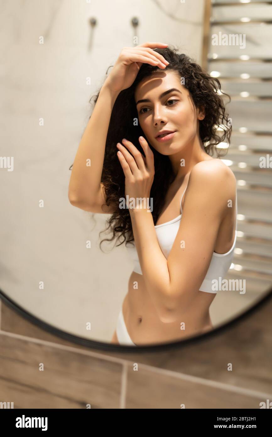Woman looking on reflection in the mirror after shower Stock Photo Alamy
