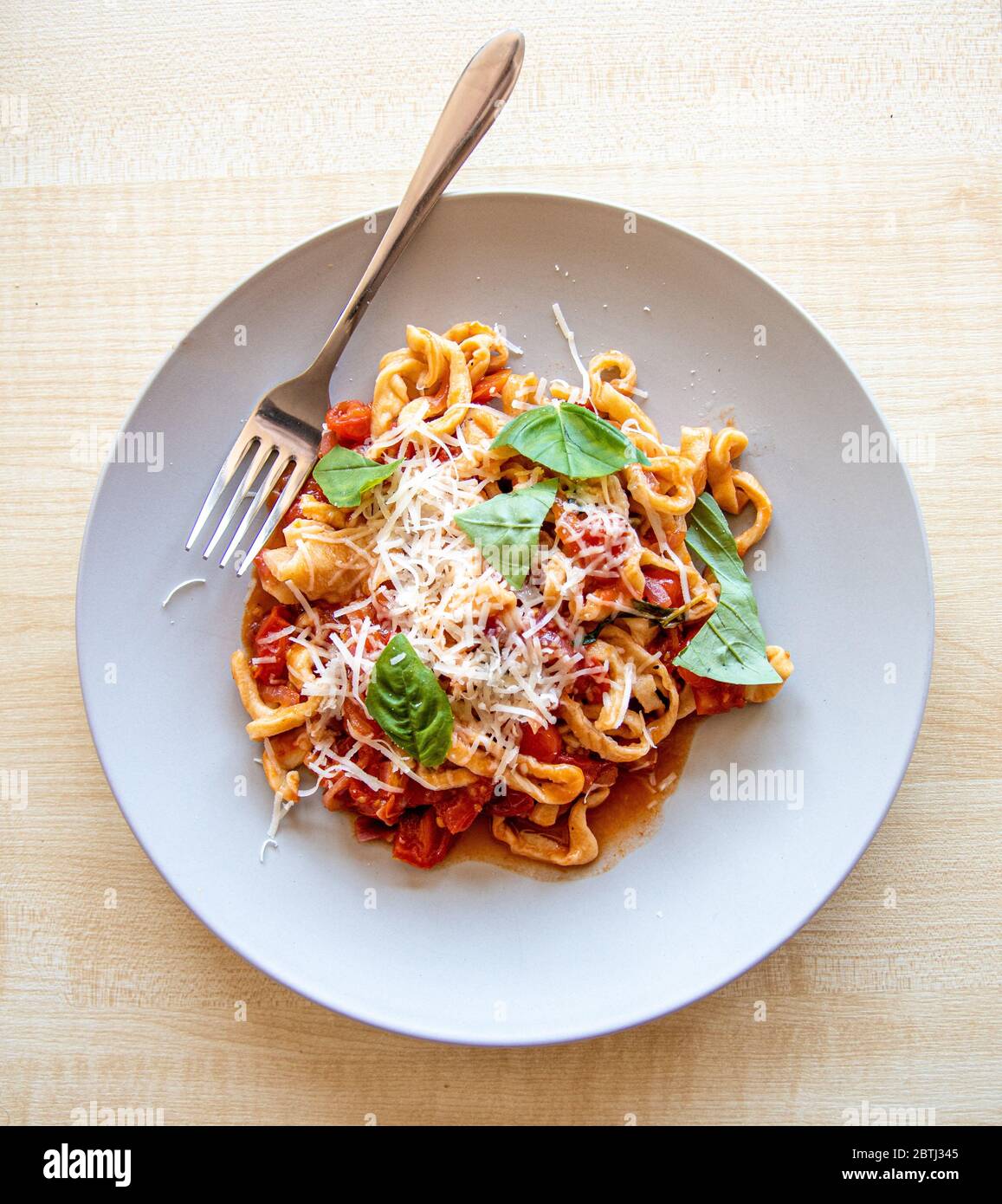 A fresh plate of delicious pasta with tomato and basil sauce made the traditional Italian way Stock Photo