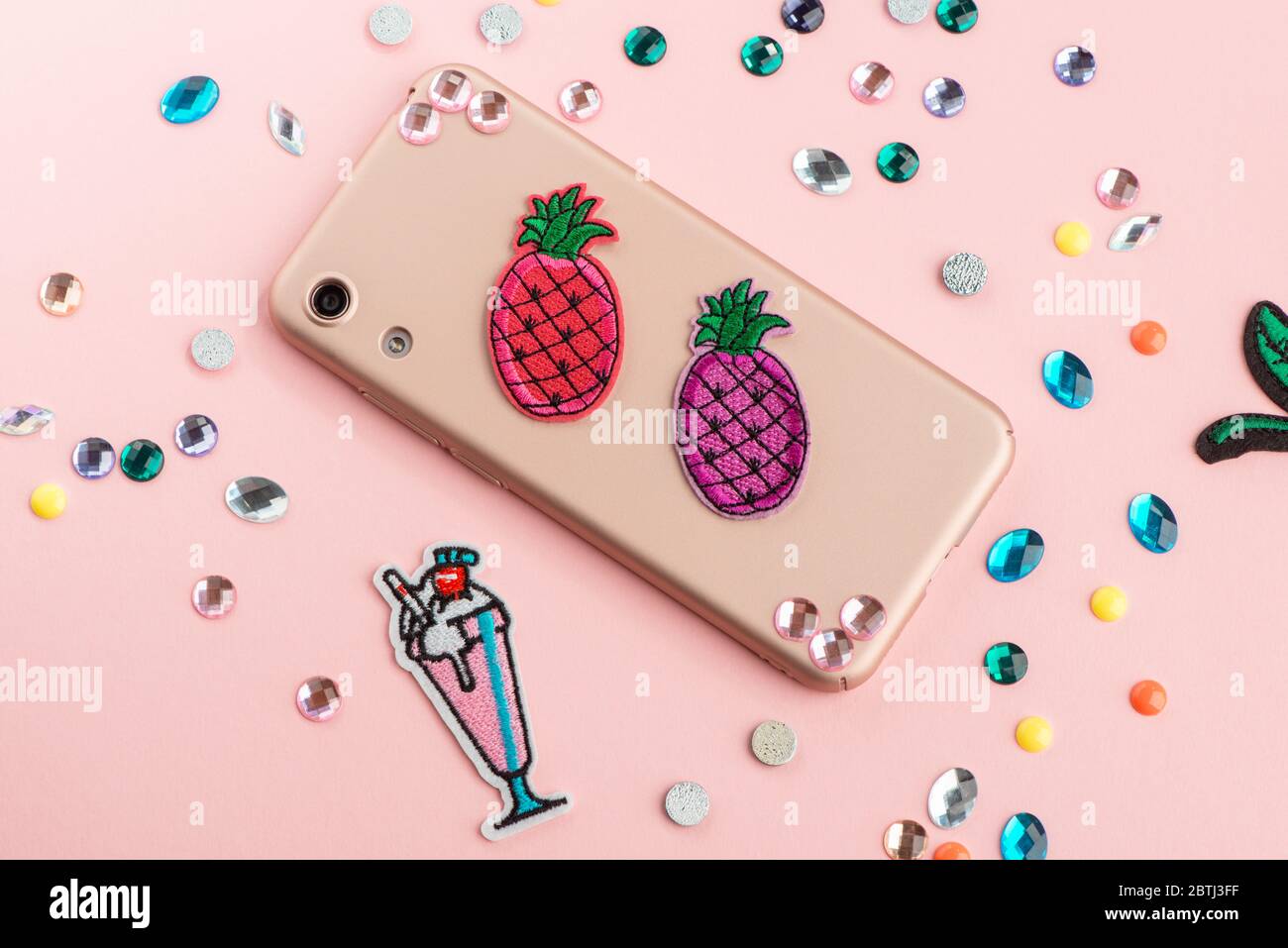 Colorful pineapple patches and rhinestones on beige phone case Stock Photo