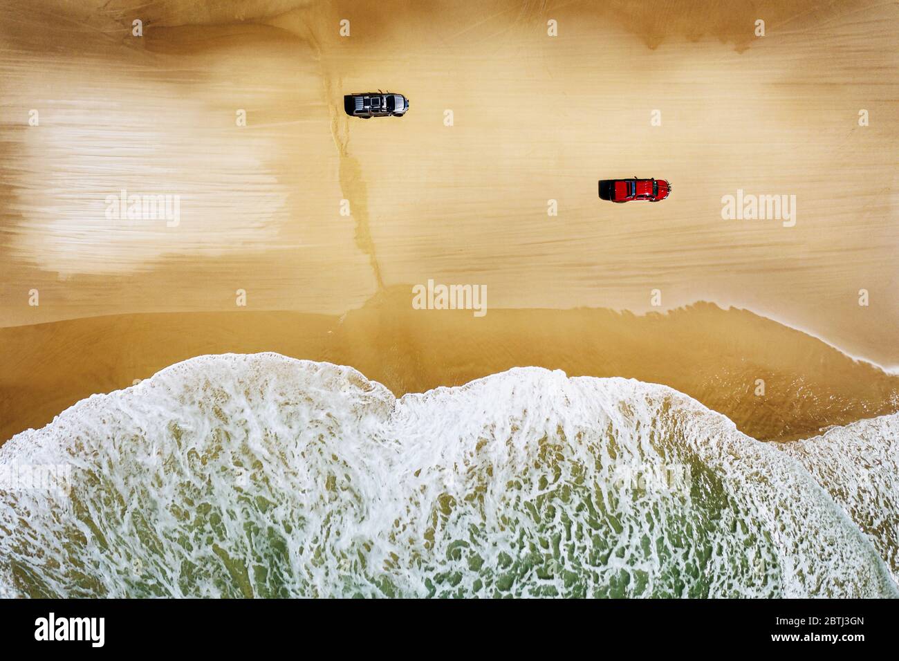 Two cars driving along Fraser Island's Seventy Five Mile Beach. Stock Photo