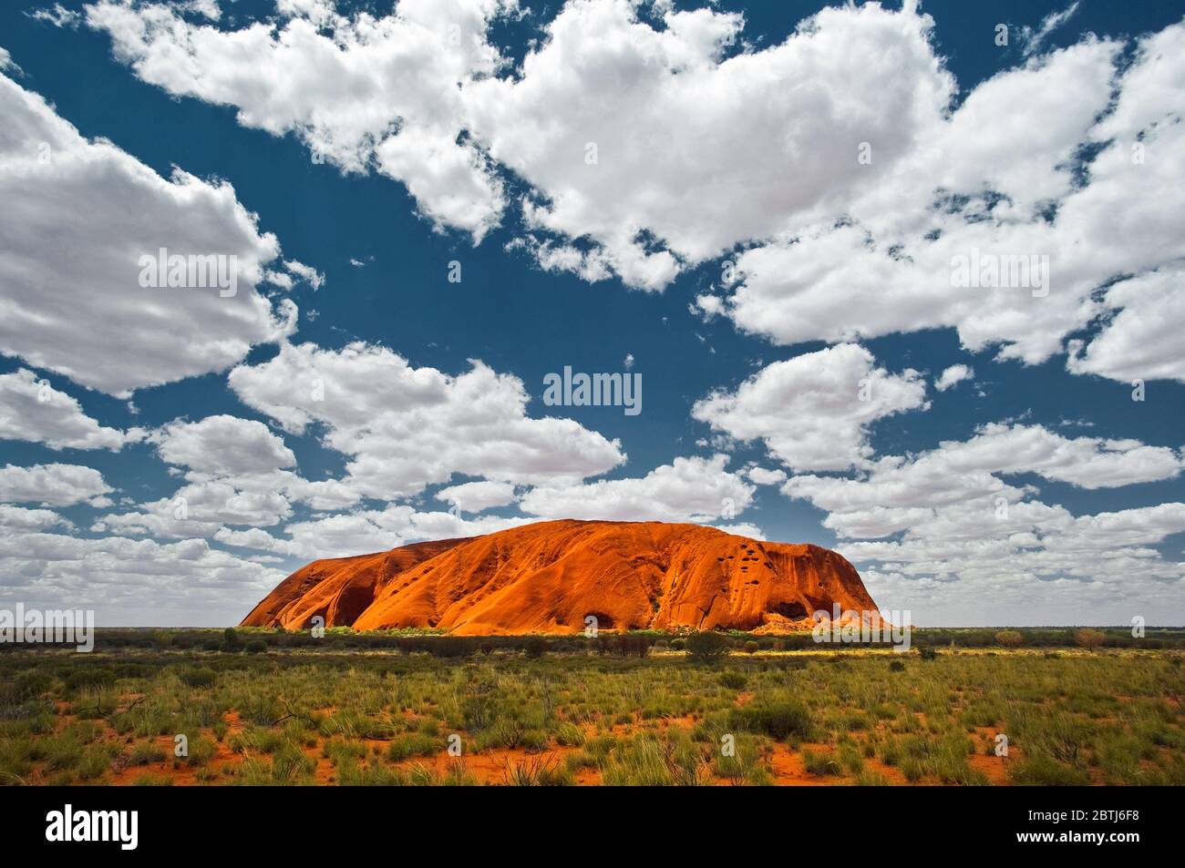 Majestic Uluru in red desert plain. Stock Photo