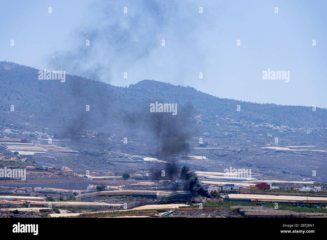 Black smoke from rubbish burning polluting the air in the hillside during phase two of the de-escalation of the state of emergency, covid 19, coronavi Stock Photo
