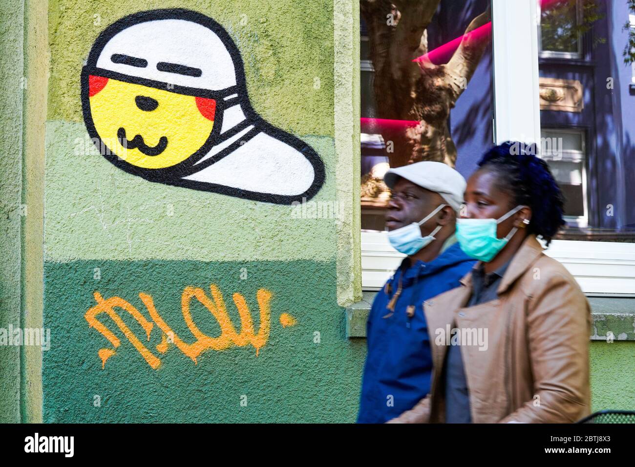Dortmund, Germany, May 26th, 2020: Mask worms. Since the outbreak of the corona crisis in March 2020, small corona virus graffiti with a mouth mask created by an unknown sprayer can be seen on many house walls in Dortmund. --- Dortmund, 26.05.2020: Maskenwürmchen. Seit Ausbruch der Corona-Krise im März 2020 sind kleine Coronaviren-Graffitis mit Mundschutz eines unbekannten Sprayers an vielen Hauswänden in Dortmund zu sehen. Stock Photo