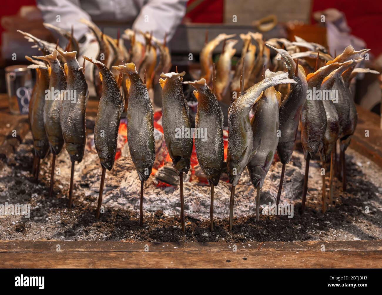 tokyo, japan - march 30 2020: Japanese ayu fish skewers also called sweetfish grilled with salt and cooked in circle in a traditional robatayaki cooki Stock Photo