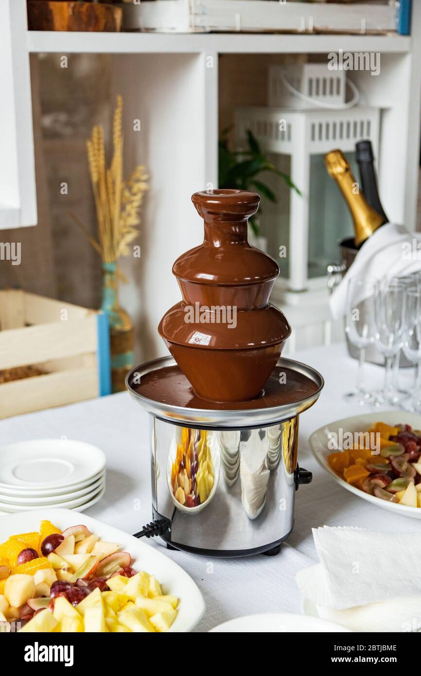 small belgian chocolate fountain, fondue, fruits, champagne Stock Photo
