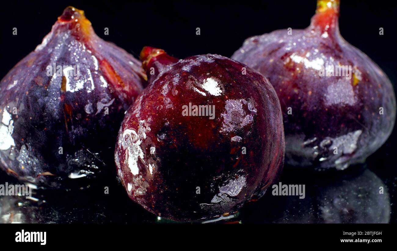 Over Ripped Figs Clsoeup photo of wet ripe figs over black backgrund. Abstract ...