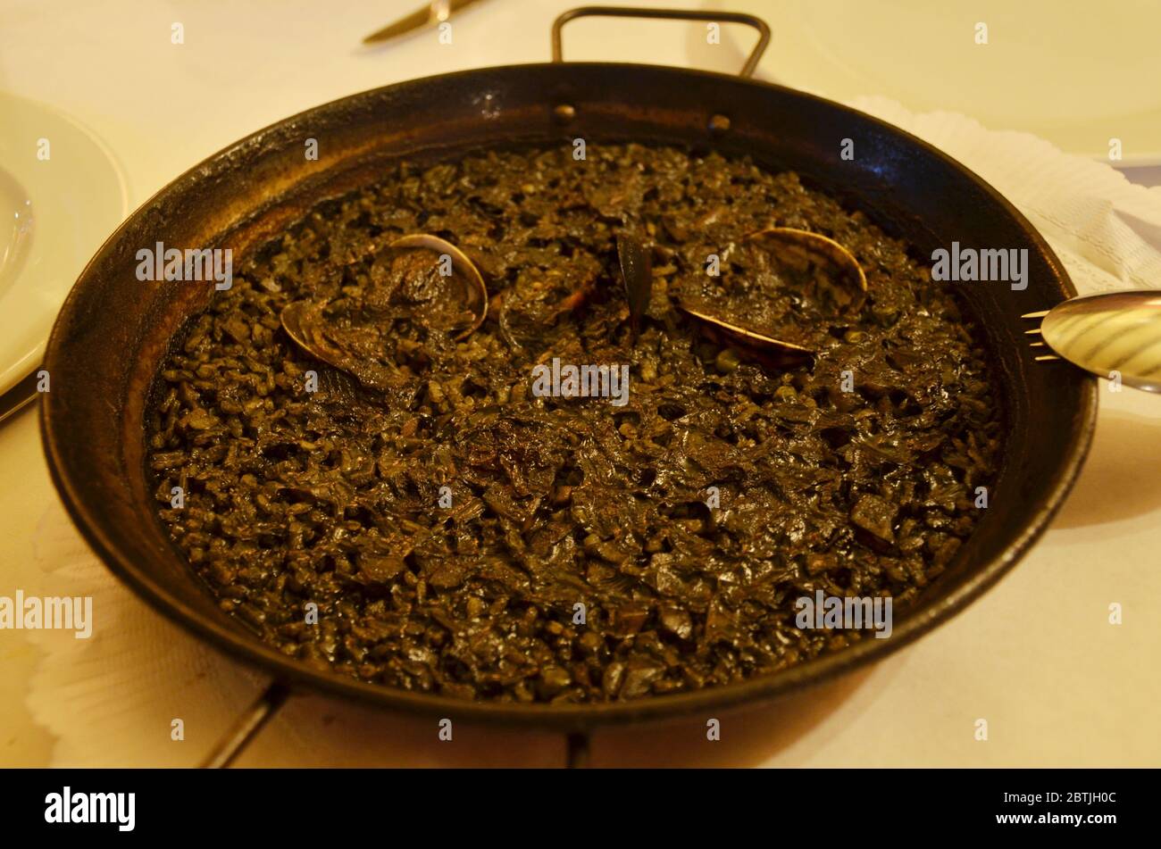Paella is a Spanish squid ink rice dish originally from Valencia. Seafood paella from a local cafe at Barcelona. Stock Photo