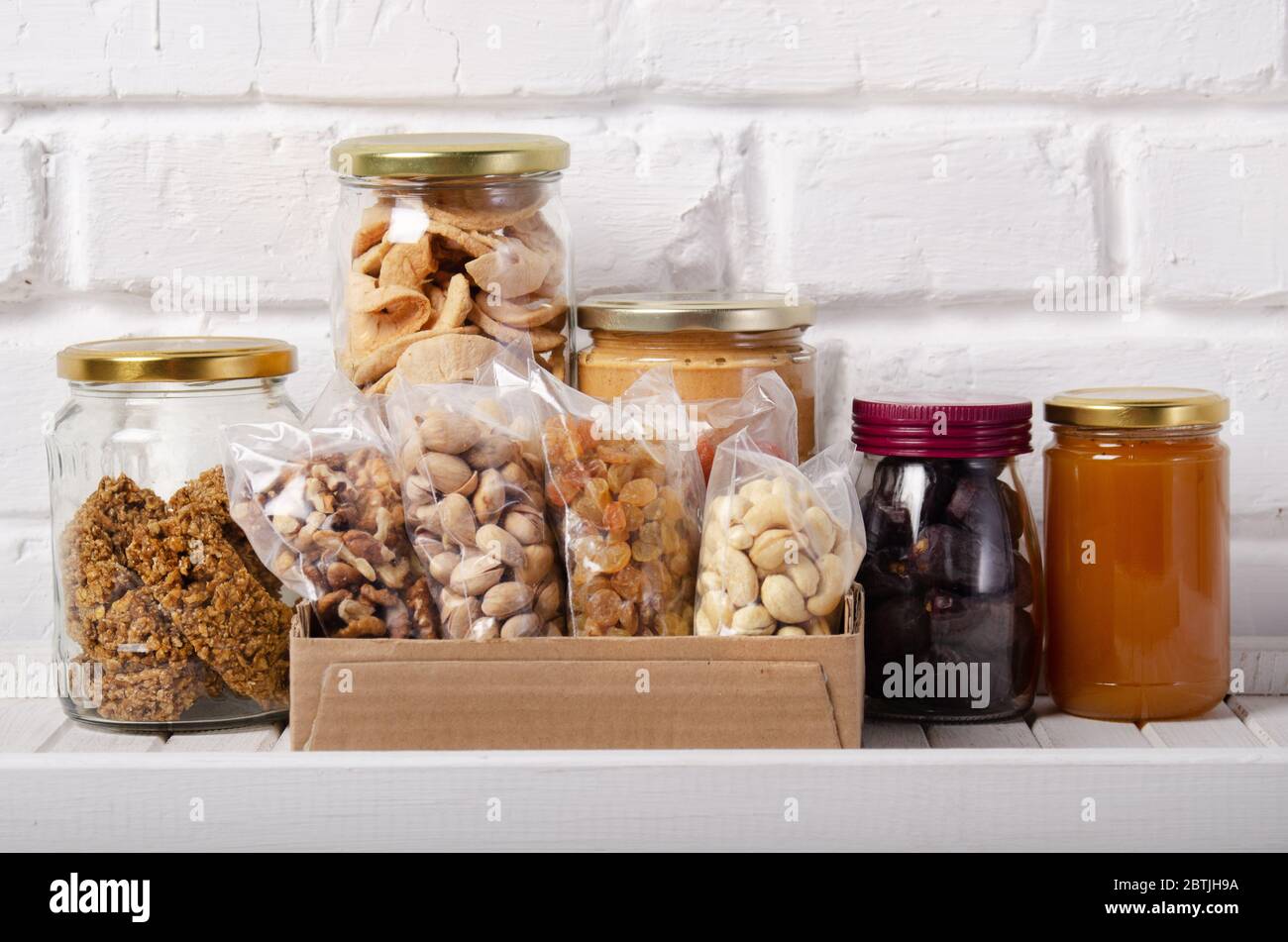 Set of long storage term mostly dry sweet energy foods on pantry shelf on brick wall background Stock Photo