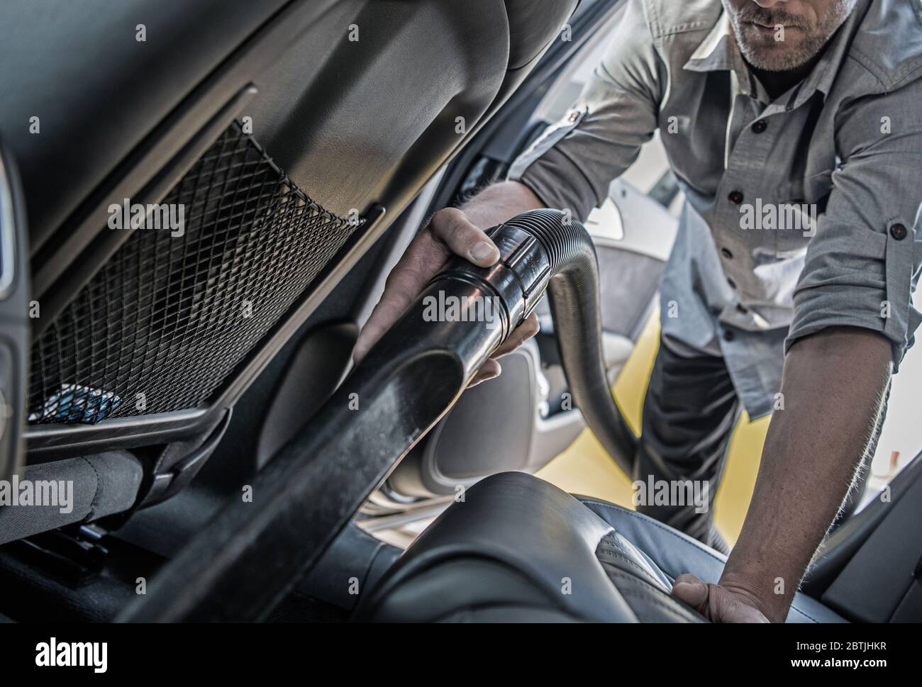 Keeping Car Clean Inside. Caucasian Men Cleaning His Car by Vacuuming