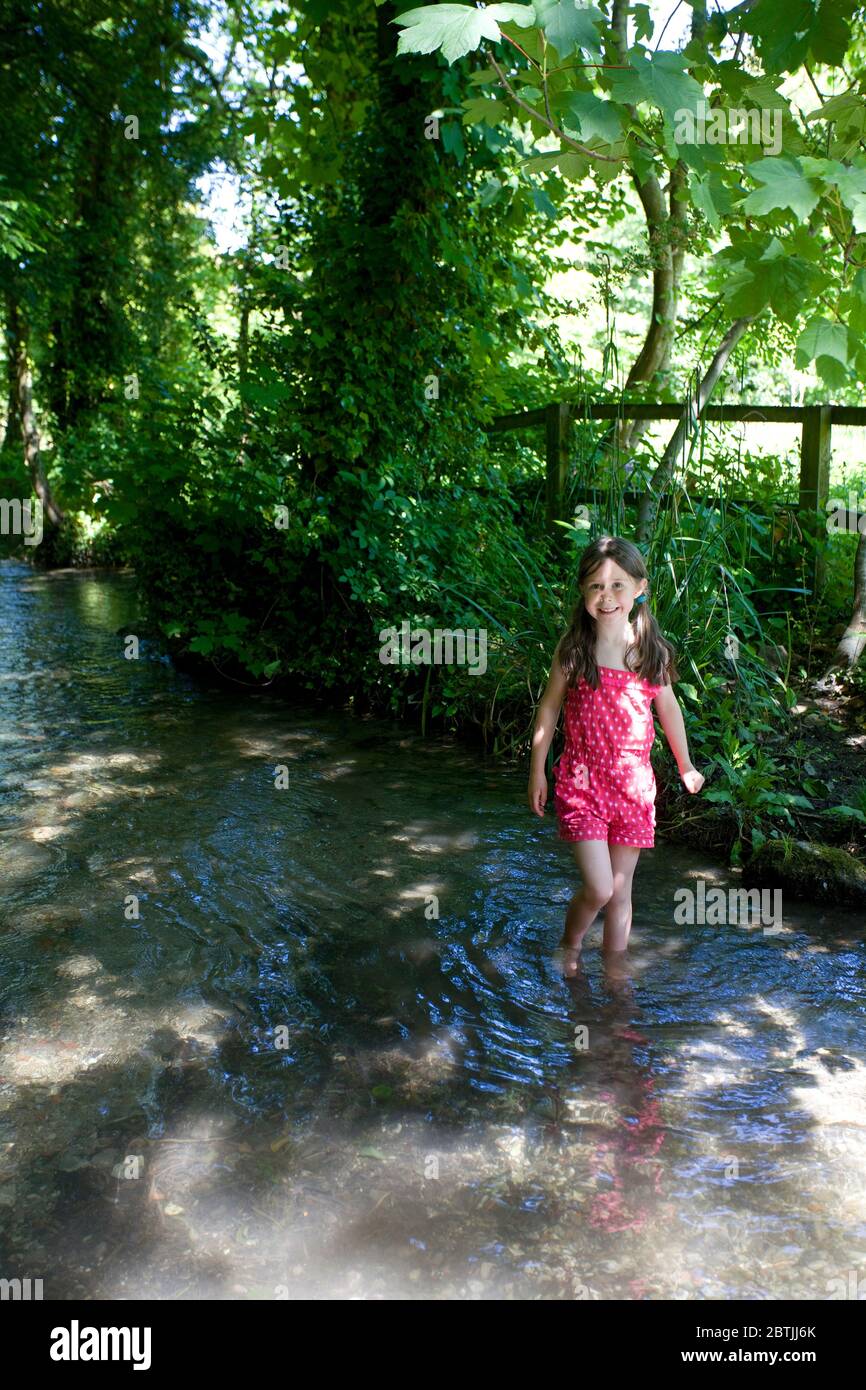 Young girl paddling in a stream, Uk Stock Photo