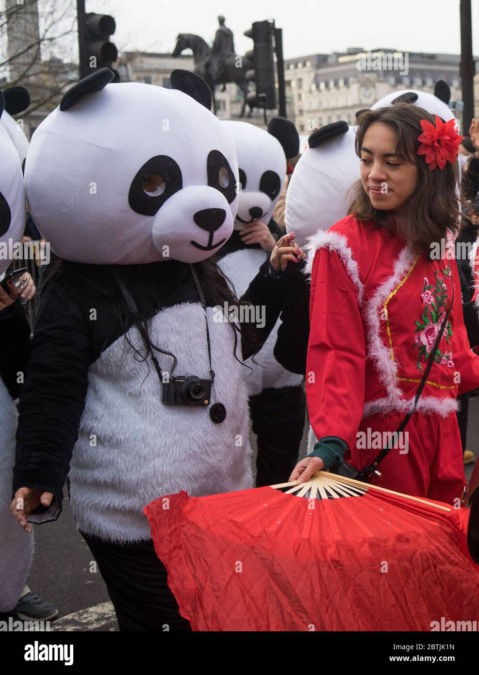Lady in red costume next to people dressed as pandas. Chinese New Year Celebration Parade. London Stock Photo
