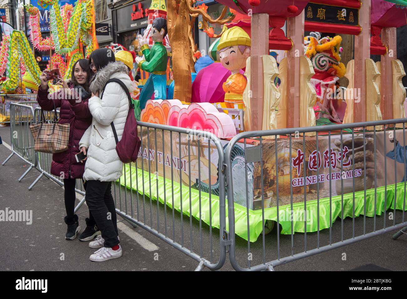 Tourists taking a selfie next to a parade float. Chinese New Year Celebration Parade. London Stock Photo
