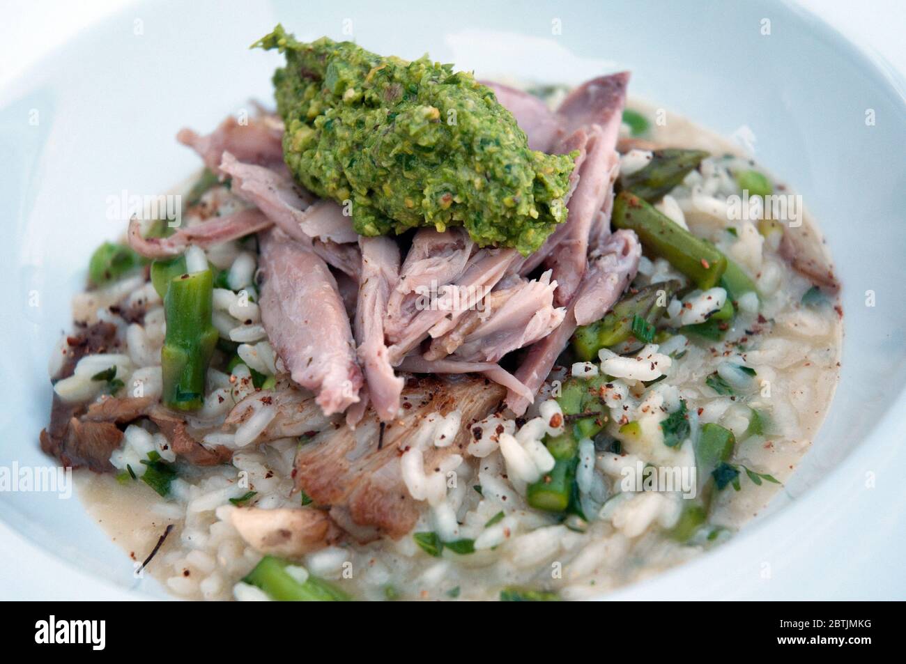 A gourmet rabbit and risotto with asparagus and a dollop of pesto served at a B&B in Notre Dame Des Bois, Eastern Townships, Quebec, Canada. Stock Photo