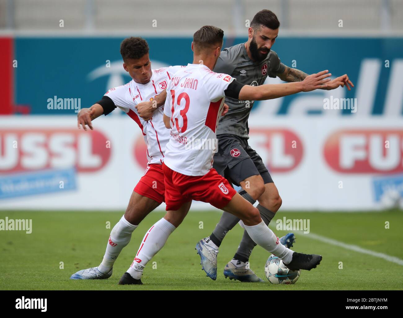 Regensburg, Germany. 26th May, 2020. Football: 2nd Bundesliga, Jahn Regensburg - 1st FC Nürnberg, 28th matchday in the Continental Arena. Chima Okoroji (l-r) and Erik Wekesser from Regensburg in action against Mikael Ishak from Nuremberg. IMPORTANT NOTE: In accordance with the regulations of the DFL Deutsche Fußball Liga and the DFB Deutscher Fußball-Bund, it is prohibited to use or have used in the stadium and/or from the game taken photographs in the form of sequence pictures and/or video-like photo series. Credit: Daniel Karmann/dpa-Pool/dpa/Alamy Live News Stock Photo