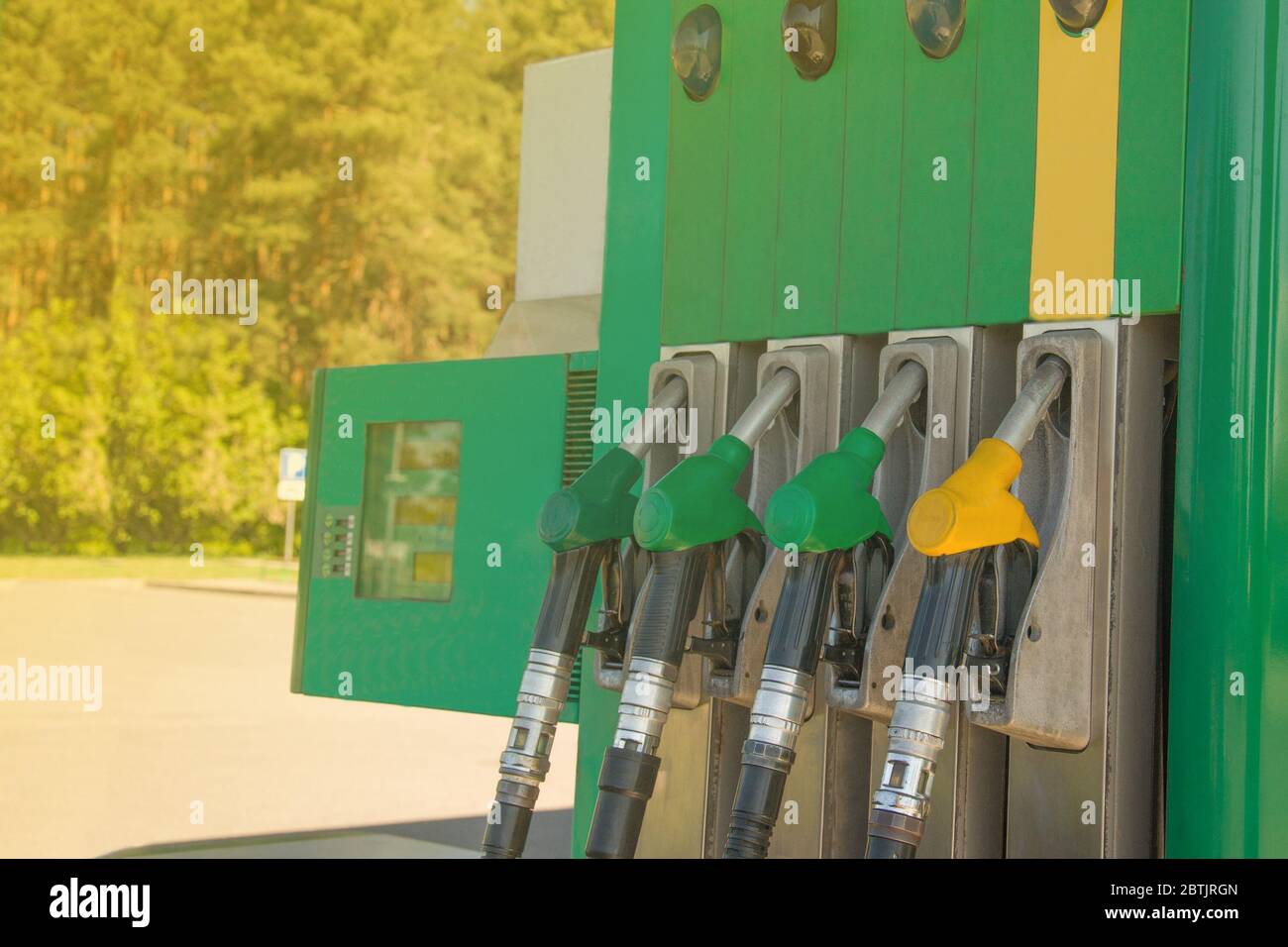 Gas station with the rays of the sun. Colorful petrol pump filling