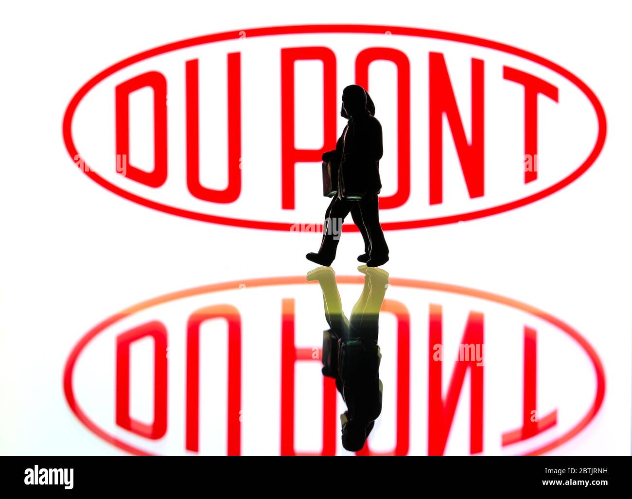 silhouettes in front of the logo for DuPont (editorial use only) Stock Photo