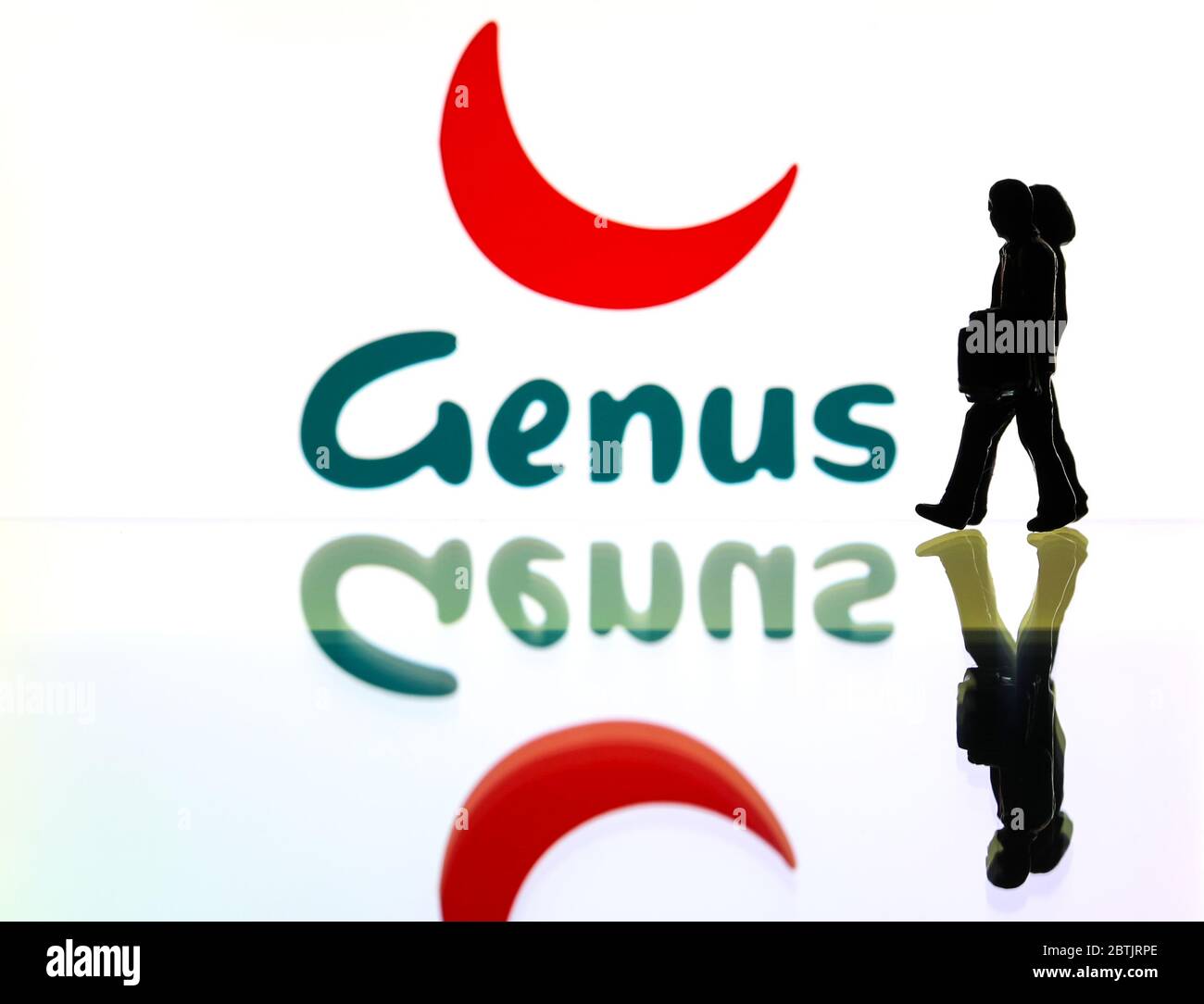 silhouettes in front of the logo for Genus PLC (editorial use only) Stock Photo