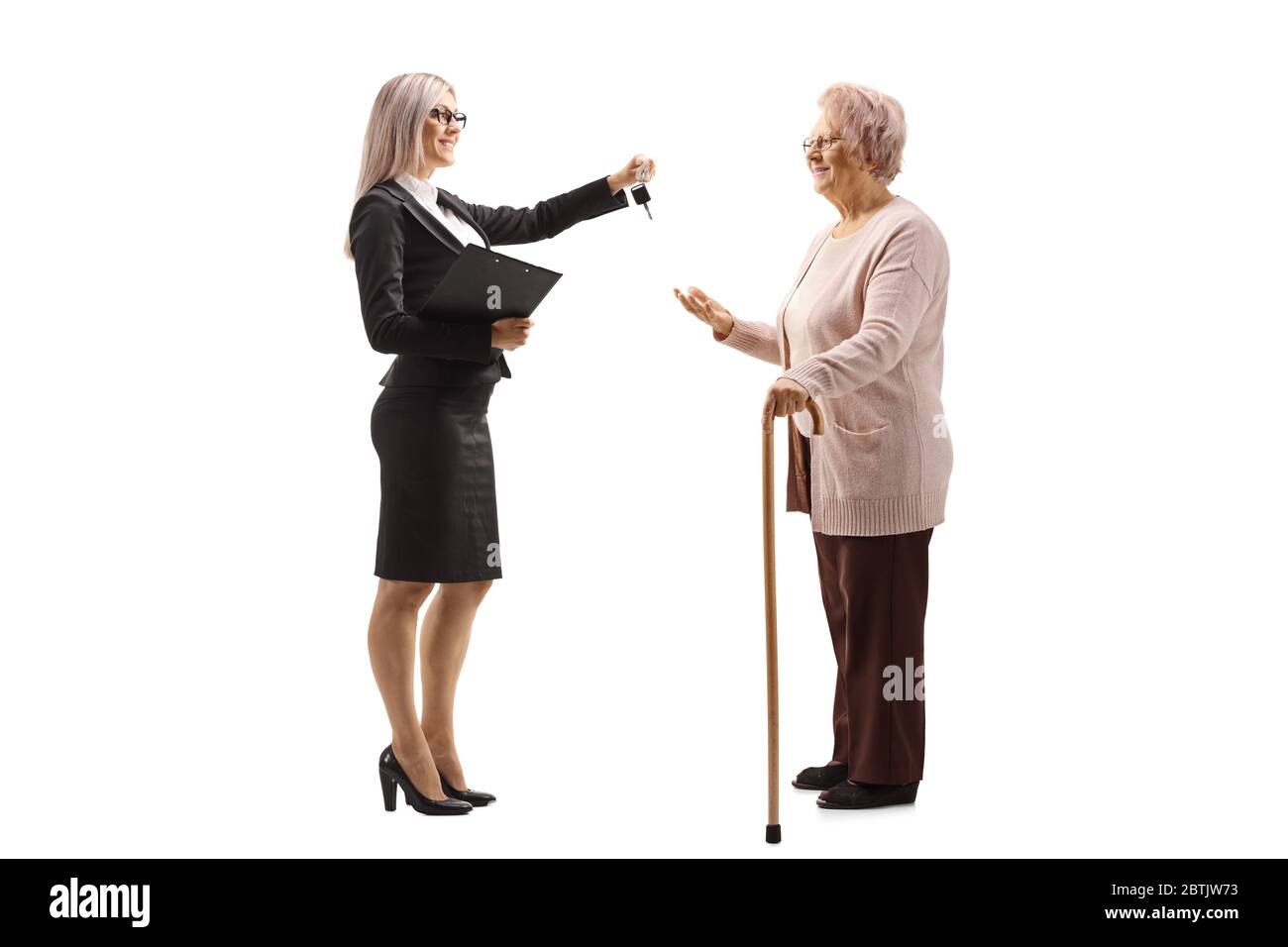 Full length profile shot of a professional woman giving car keys to an elderly woman with a walking cane isolated on white background Stock Photo