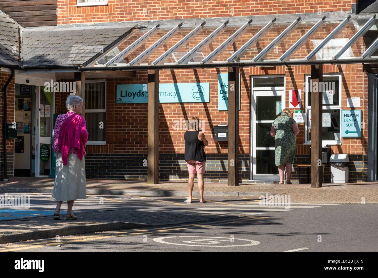 Socially distanced queue at Fleet Community Hospital and pharmacy during the 2020 coronavirus covid-19 pandemic, Hampshire, UK Stock Photo