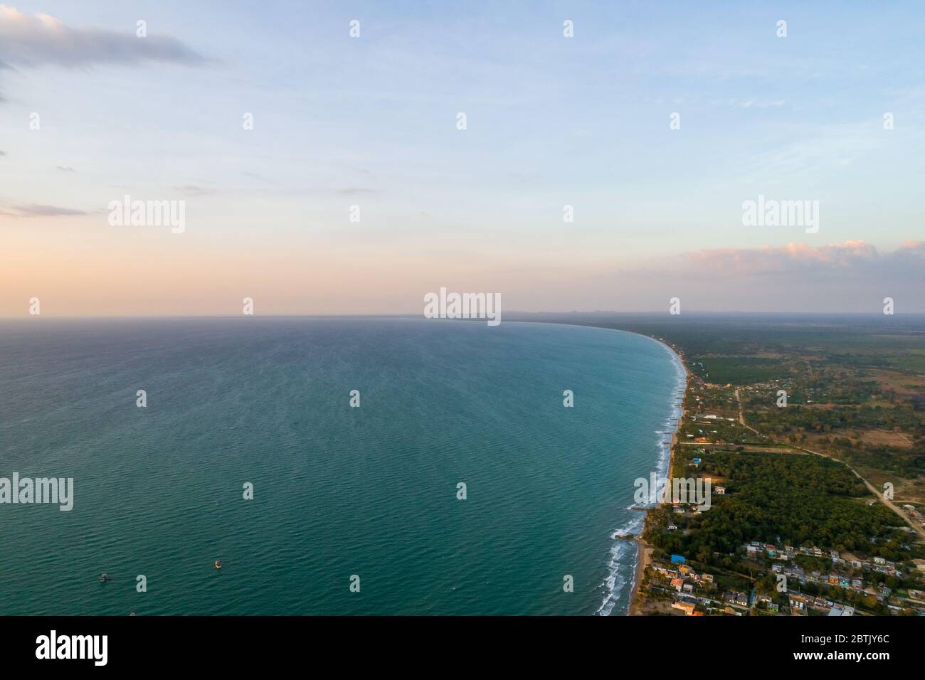 Aerial view of paradisiacal beaches at the Colombian Caribbean, showing emerald green and blue waters and pacific waves arriving to the shore Stock Photo