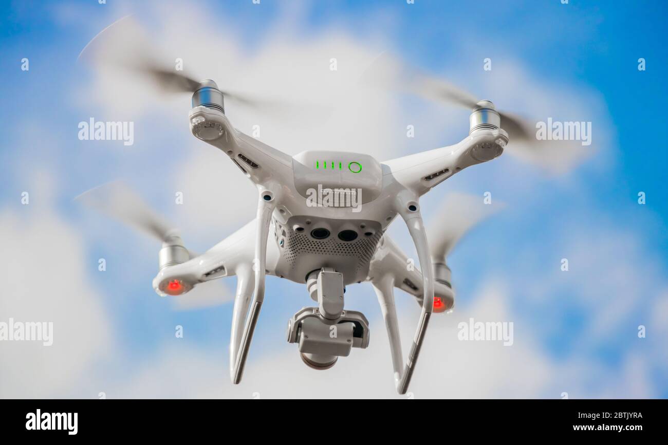 A bottom up view of a drone taking off with its propellers at maximum speed Stock Photo