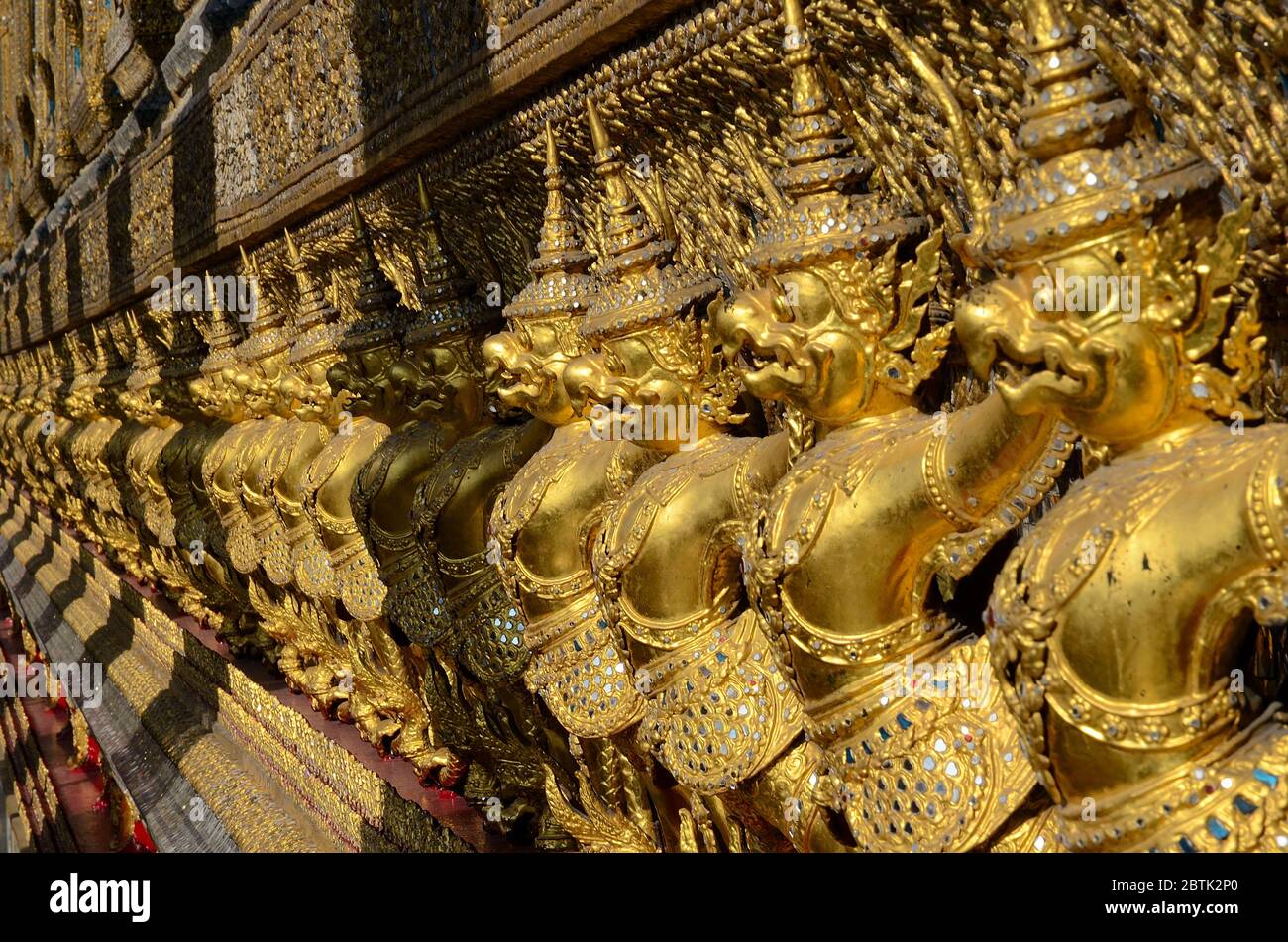 Row of golden garudas at Wat Phra Kaew in Bangkok Stock Photo