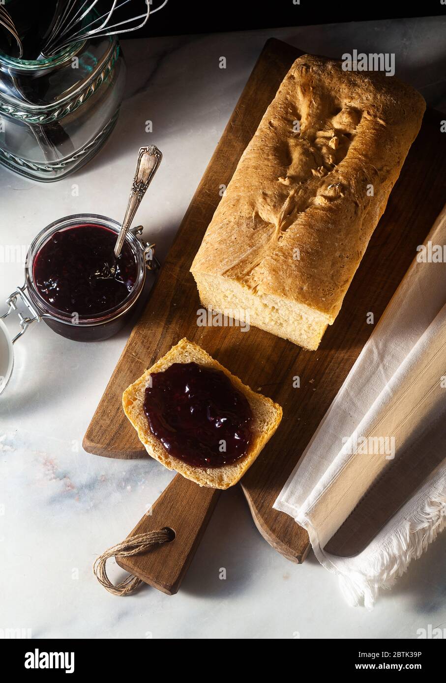 Fresh homemade sandwich bread and jam in a jar on the kitchen table ...