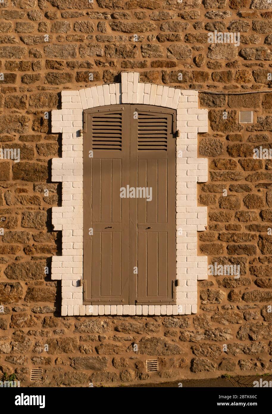 brown closed shutter with white surroundings on a stone wall Stock ...