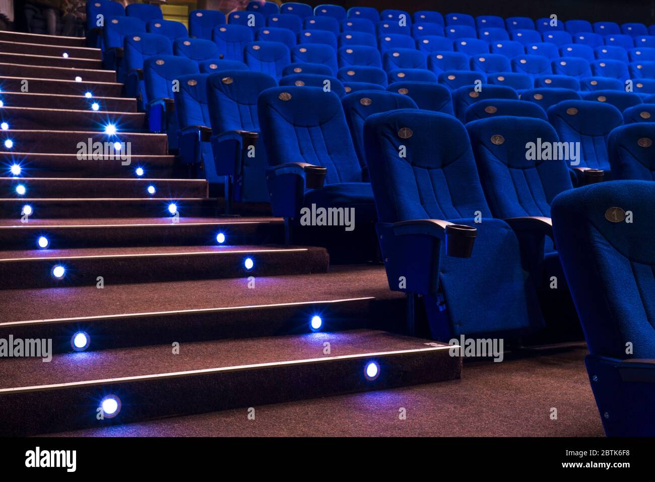 Empty comfortable red seats with numbers in cinema General plan of