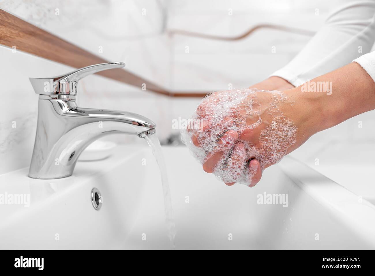 Someone washes hands with soap while standing in the bathroom. Stock Photo