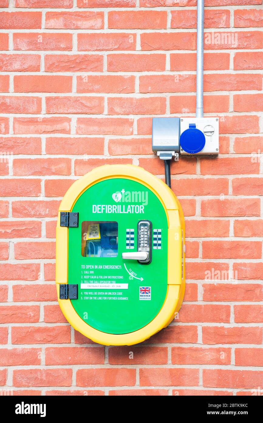 Defibrillator on a brick wall, UK. Stock Photo