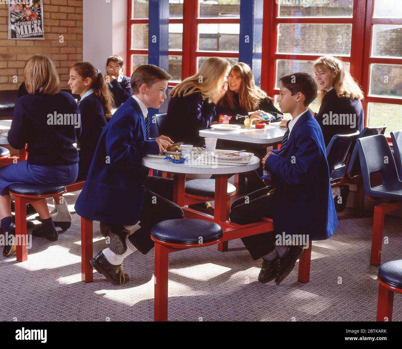 Children iseated n secondary school canteen, Surrey, England, United Kingdom Stock Photo