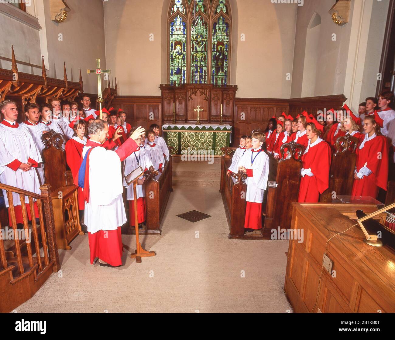 Choirmaster conducting choir in church, Surrey, England, United Kingdom Stock Photo