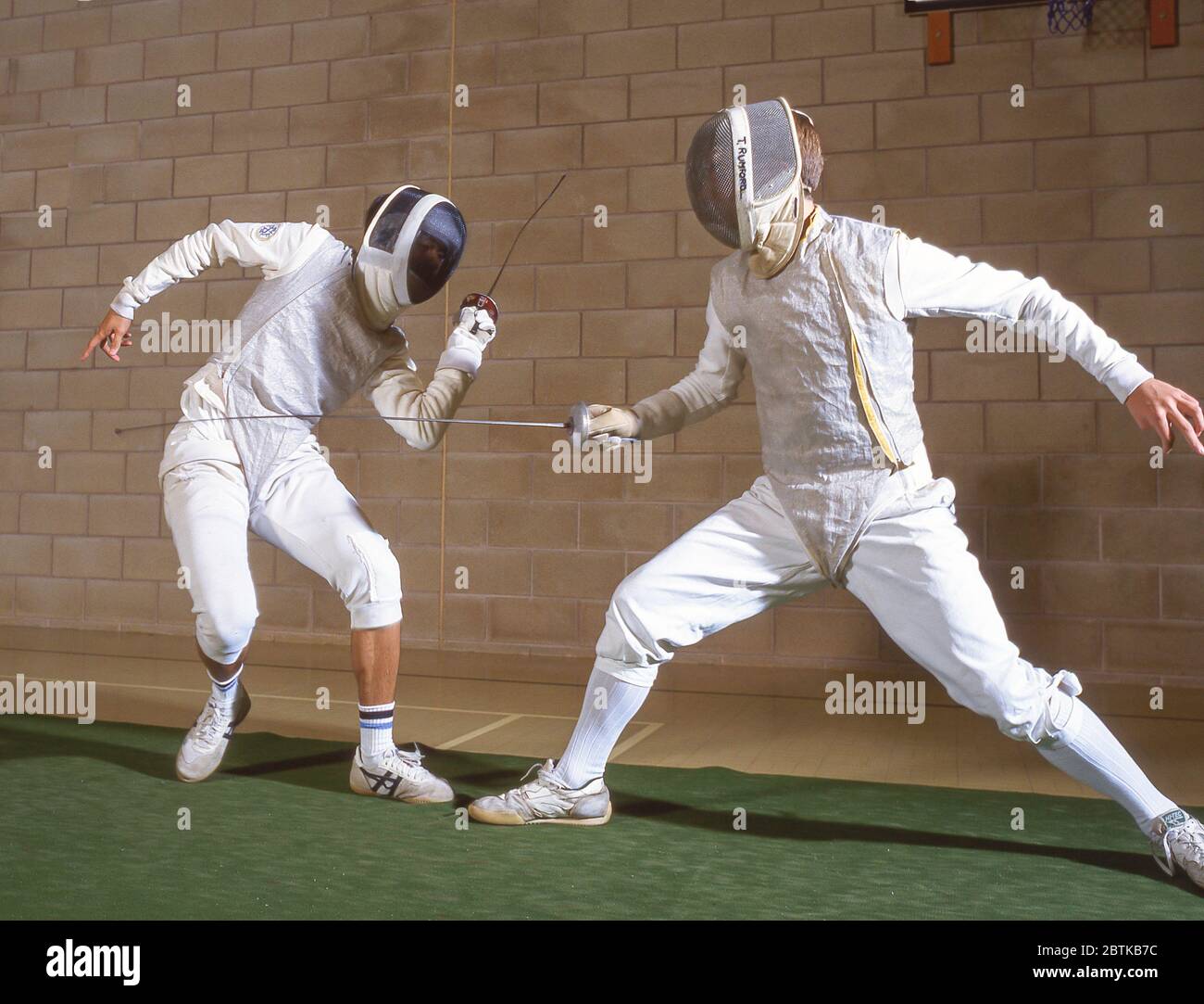 School boys fencing in school gym, Surrey, England, United Kingdom Stock Photo