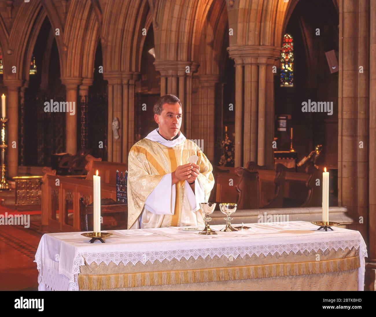 Vicar at church altar, Surrey, England, United Kingdom Stock Photo