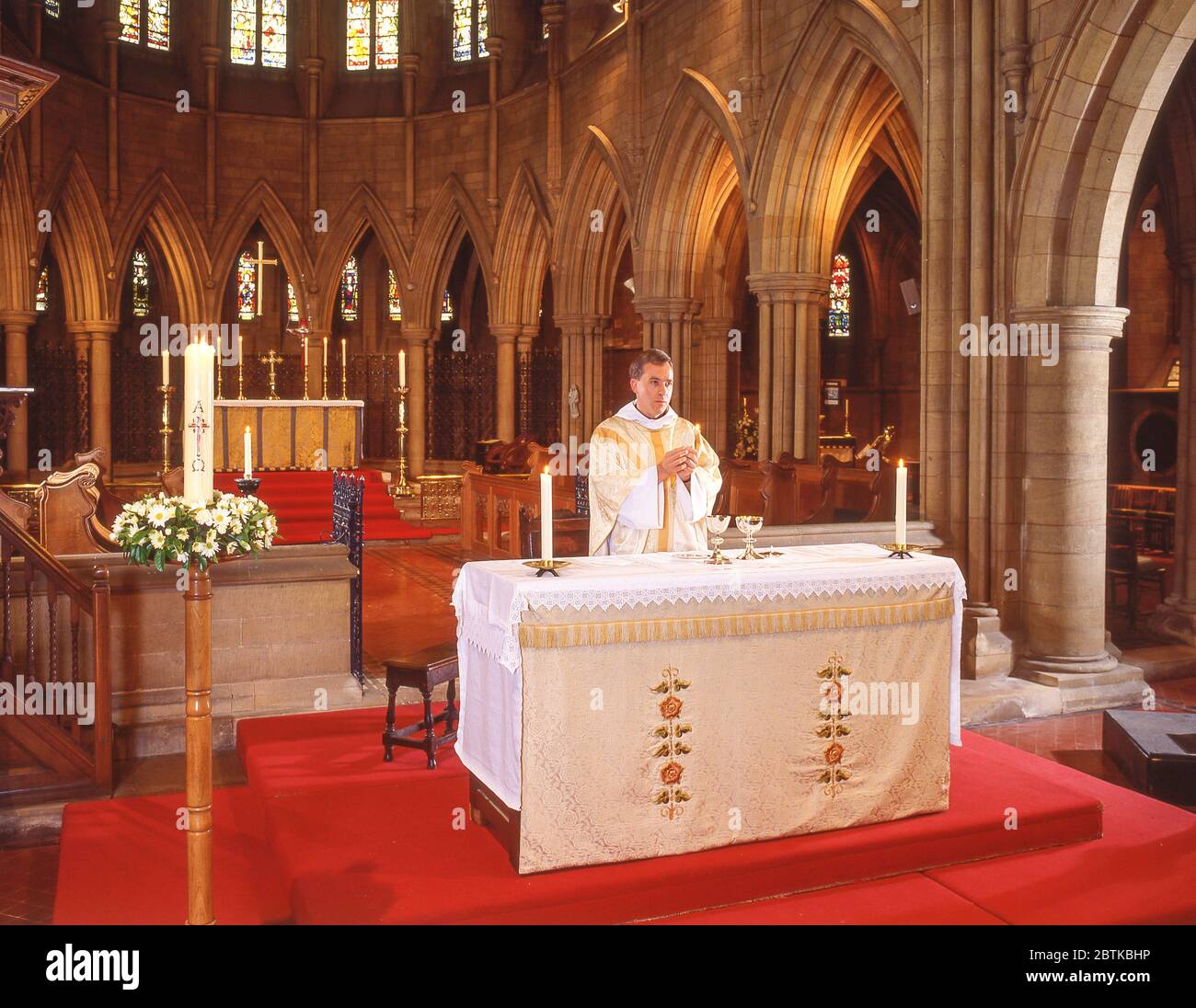Vicar at church altar, Surrey, England, United Kingdom Stock Photo