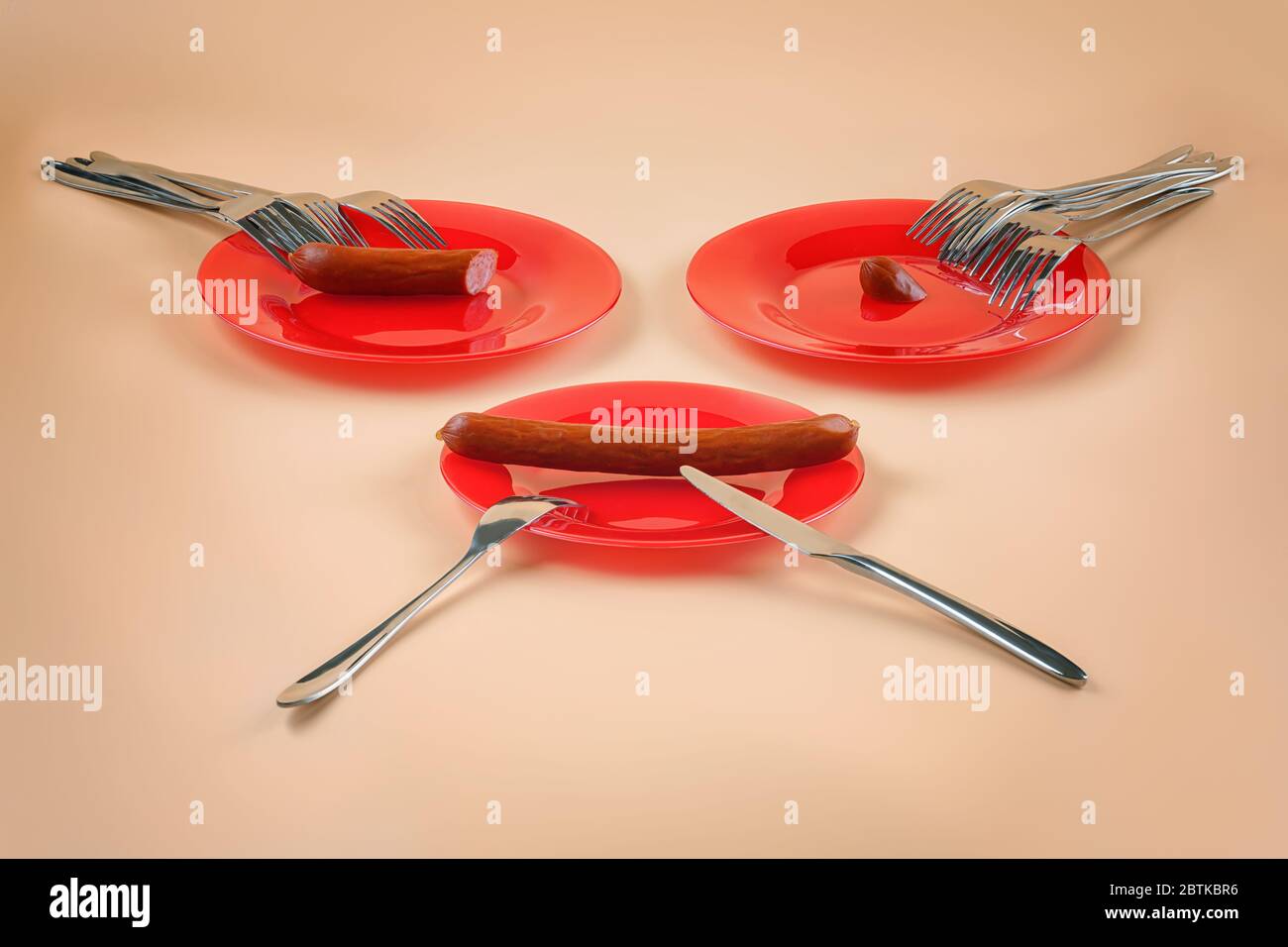Three plates, three different sausage portions and many forks. Metaphor for disproportion and inequality in allocating budget, wages, resources, funds Stock Photo