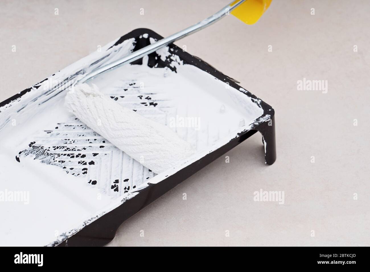 Closeup roller in tray with white pint Stock Photo